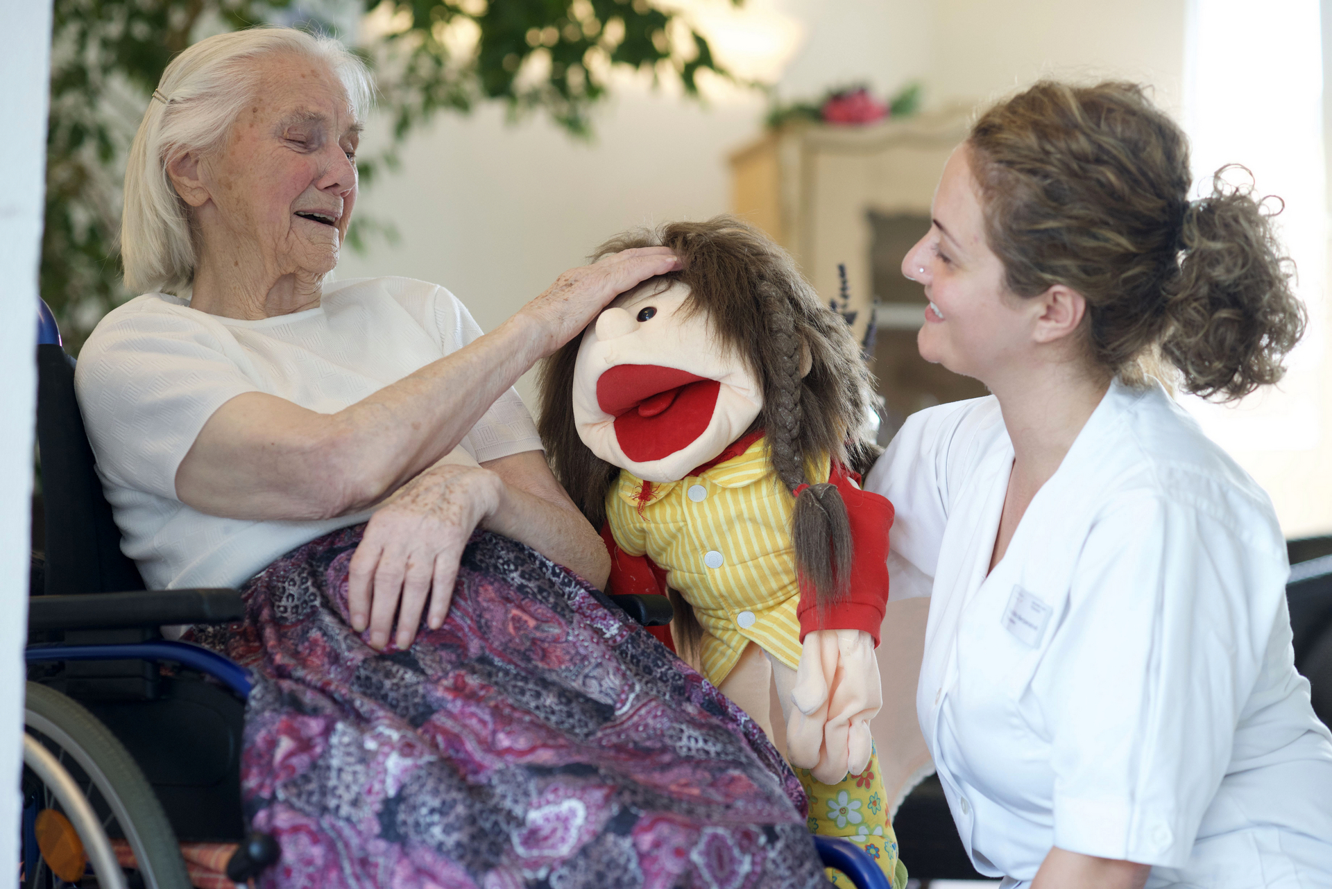 Eine Patientin und eine Pflegekraft lachen gemeinsam.